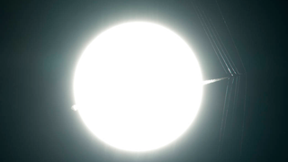 A Supersonic Jet and Its Shock Waves Appear to Pierce the Sun